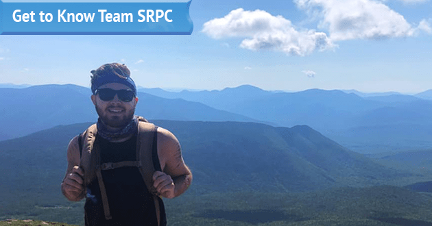 GIS Planner Jackson Rand poses at the top of a mountain for his submitted photo for his "Get to Know Team SRPC" blog feature