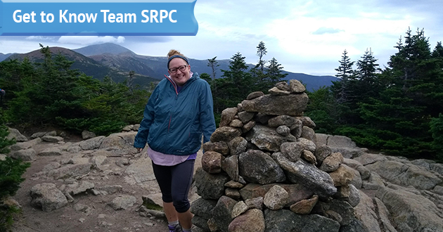 Communications and Outreach Planner Shayna Sylvia poses at the top of a mountain for her submitted photo for her "Get to Know Team SRPC" blog feature