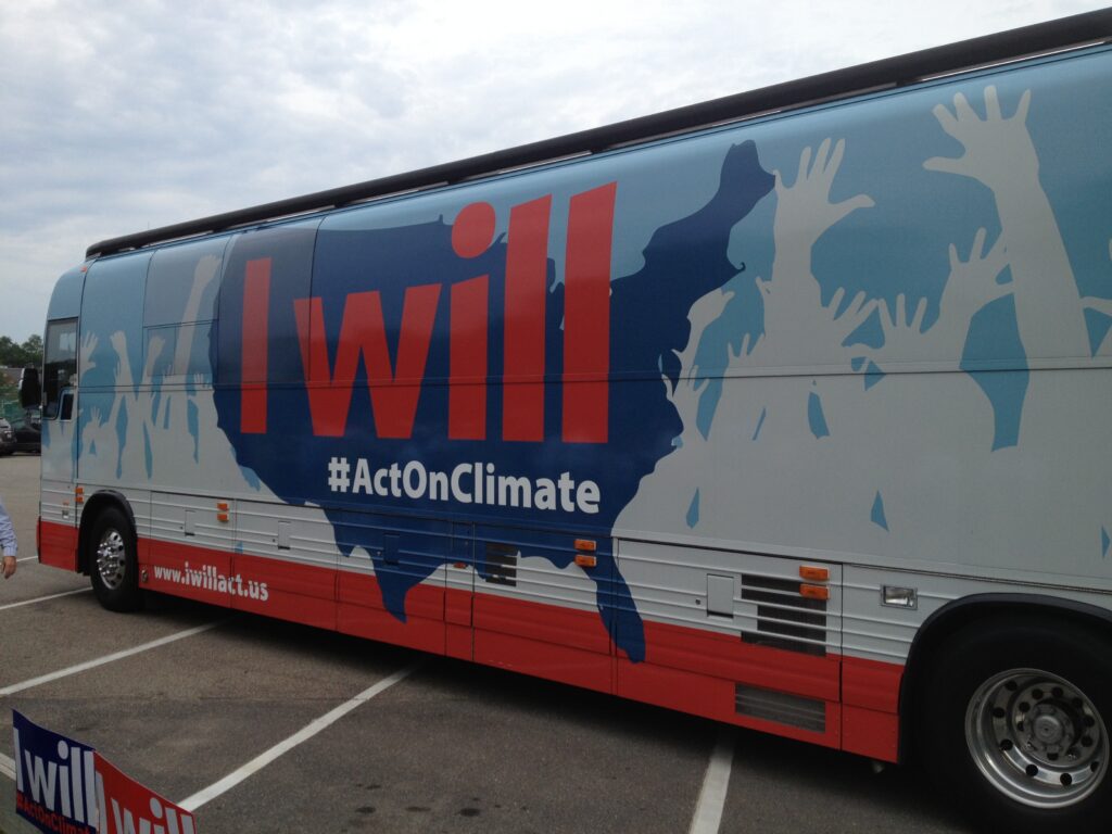 Bus with a wrap that reads "I will #Act On Climate"