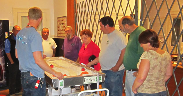 A group of citizens gathering around a flume display at a river workshop