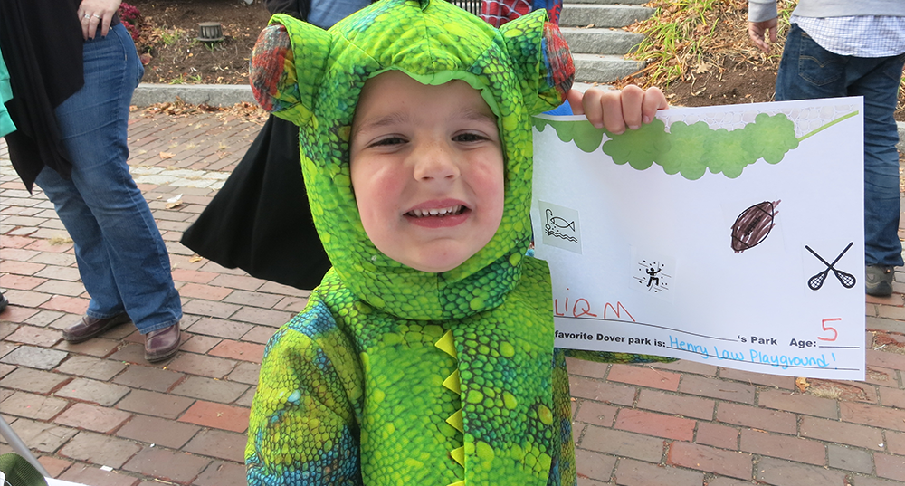 A boy dressed up as a gecko at the downtown trick or treat shows the dream park he drew as part of outreach for Dover's recreation plan