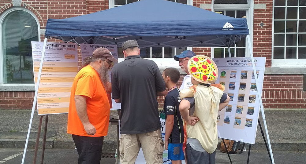 Participants gather at a booth at Farmington Hay Day to take part in outreach exercises to gather input on the town's future.